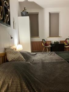 Un dormitorio con una cama y una silla y ventanas. en Lumiēre Studio 1, en Sfântu-Gheorghe 7 fotos más