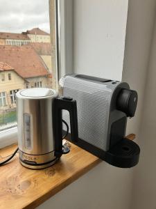 Una tostadora colocada en el alféizar de una ventana junto a un microondas. en Lumiēre Studio 1, en Sfântu-Gheorghe