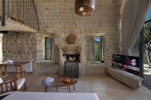 ein Wohnzimmer mit einer Steinmauer und einem Kamin in der Unterkunft Casadar Guesthouse in Ash Shi‘b