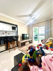 una sala de estar llena de animales de peluche en Ap Frente Mar, wi-fi, piscina, pet, check-in e check-out flexíveis, en Praia Grande