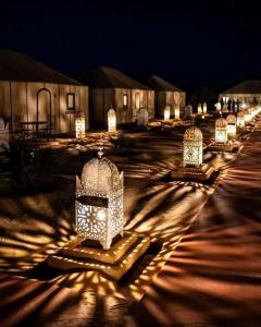 a row of white lights in a parking lot at night at Camp trip luxury in Merzouga