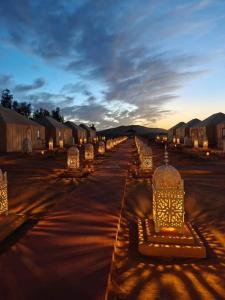 a row of benches in a parking lot with lights at Camp trip luxury in Merzouga
