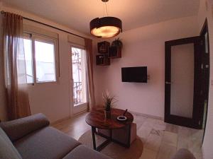 een woonkamer met een bank en een tafel bij Amanecer Andaluz in Ronda