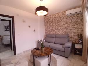 een woonkamer met een bank en een tafel bij Amanecer Andaluz in Ronda