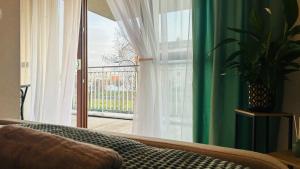 een woonkamer met een bank en een groot raam bij Apartament Słoneczny 16 in Opole