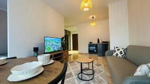 een woonkamer met een bank en een tafel bij Apartament Słoneczny 16 in Opole