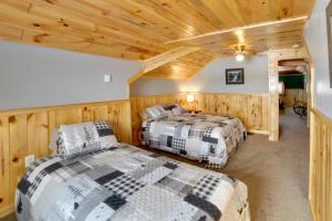 twee bedden in een kamer met houten wanden bij Secluded and Peaceful Upper Peninsula Getaway! in Chatham