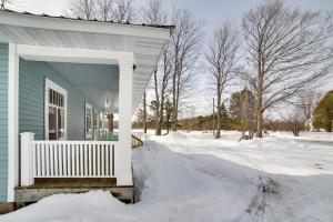 een blauw huis met een veranda in de sneeuw bij Secluded and Peaceful Upper Peninsula Getaway! in Chatham