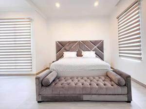a bedroom with a bed with a tufted headboard at Dazzling Lekki 3BR Home - Private Balcony - 247 Power, Wifi & Security in Lekki