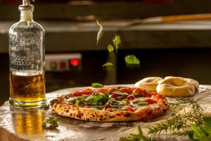 a pizza sitting on a table next to a bottle at Pousada Fazenda Aroeira Secretário in Itaipava