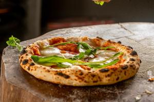a pizza sitting on top of a wooden table at Pousada Fazenda Aroeira Secretário in Itaipava
