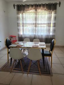 a dining room with a table and chairs and a window at Creek apartment in Kilifi +14 photos