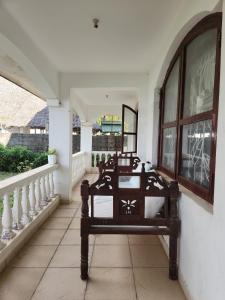 a porch with a bench in a house at Creek apartment in Kilifi