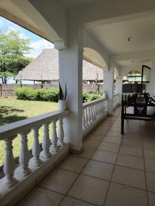 a porch with a white railing and a chair on a house at Creek apartment in Kilifi