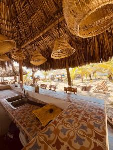 a bathroom with a sink under a straw umbrella at Casa Origen Boutique en San Bernardo del Viento in San Bernardo del Viento