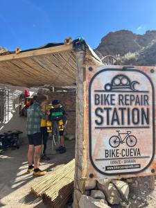 a sign for a bike repair station with people standing around at Bike Cueva - Badlands in Gorafe