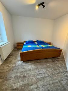 a bedroom with a bed with blue pillows on it at Apartment im Grünen in Kroppach