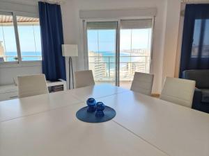 ein weißer Tisch mit zwei blauen Bechern darauf in der Unterkunft Just 1 minute from the beach A117 in Las Lagunas Mijas