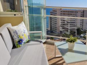 ein Wohnzimmer mit einer weißen Couch und einem Tisch in der Unterkunft Just 1 minute from the beach A117 in Las Lagunas Mijas