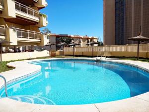 ein großer blauer Swimmingpool vor einem Gebäude in der Unterkunft Just 1 minute from the beach A117 in Las Lagunas Mijas