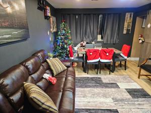 a living room with a christmas tree and a leather couch at Lux 2BR Condo with King Beds DTWN in Atlanta