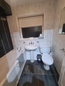 a bathroom with a sink and a toilet and a tub at Comfortable two bed apartment in Chester-le-Street