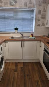 a kitchen with a sink and a washing machine at Comfortable two bed apartment in Chester-le-Street +2 photos