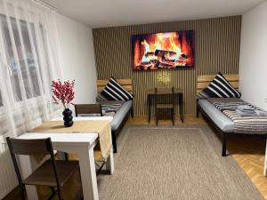 ARCOS Apartment - Geräumige 3-Zimmer-Wohnung mit 8 Einzelbetten - Perfekt für Familien, Gruppen oder Monteure في كابل غرافنهاوسن: غرفة معيشة مع لوحة نار على الحائط