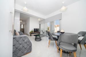 New 2 bedroom flat in Aglantzia في Aglantzia: غرفة معيشة بها طاولة وكراسي