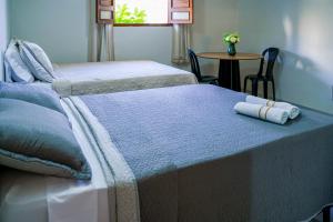 a bedroom with two beds and a table with a table at Pousada sousa Residencial Qrt 3 in Sousa