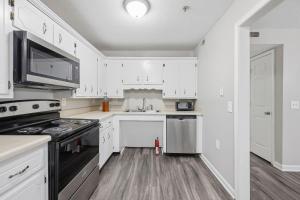een keuken met witte kasten en een kookplaat oven bij Modern Highland Park 2BR 2BA Stay in Clarksville +12 foto's