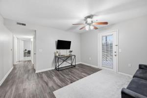een woonkamer met een plafondventilator en een bank bij Modern Highland Park 2BR 2BA Stay in Clarksville