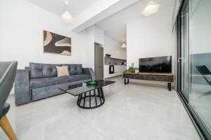 New 2 bedroom flat in Aglantzia في Aglantzia: غرفة معيشة مع أريكة وتلفزيون