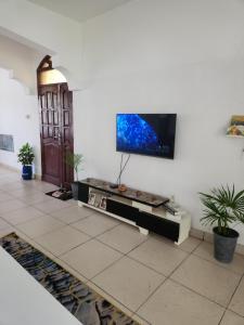 a living room with a flat screen tv on a wall at Creek apartment in Kilifi