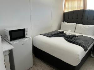 a bedroom with a bed with a tv on top of it at Sagrada Guest House in Mthatha