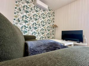 a living room with a couch and a television at Le 37 FOCH in Orange