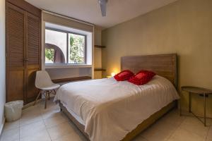 a bedroom with a bed with red pillows on it at Casa Rosa in Querétaro