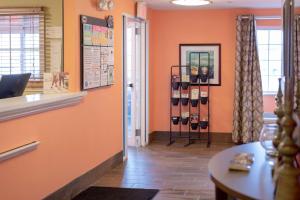 a waiting room with orange walls and a table with wine bottles at Sonesta Simply Suites Pittsburgh Airport in Imperial