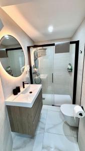 a bathroom with a sink and a toilet and a mirror at Las Americas 200 B apartment in Costa de Adeje
