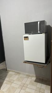 un micro-ondes posé sur un réfrigérateur dans l'établissement Beach Loft, à Vila Velha