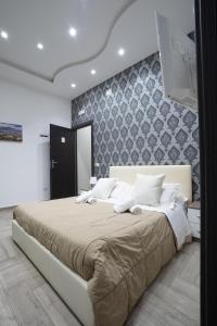 a bedroom with a large bed and a wall at La dimora del Sole in Ercolano