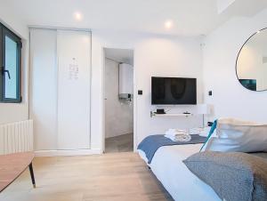 ein Schlafzimmer mit einem Bett und einem Fernseher an der Wand in der Unterkunft Be Happy - Appartement central in Argenteuil