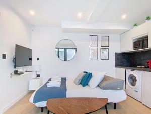 ein weißes Zimmer mit einem Bett und einer Waschmaschine in der Unterkunft Be Happy - Appartement central in Argenteuil