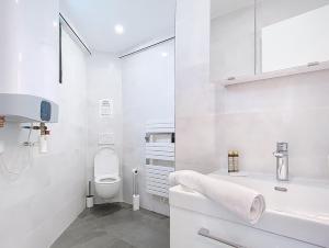 ein weißes Badezimmer mit Toilette und Waschbecken in der Unterkunft Be Happy - Appartement central in Argenteuil