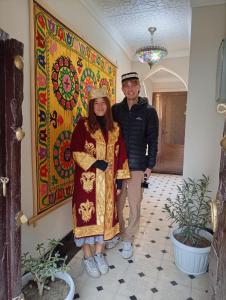 a man and a woman standing in front of a painting at Zardozon Hotel in Bukhara