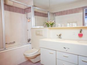 a bathroom with a toilet and a sink and a shower at Thermal Hotels & Walliser Alpentherme Leukerbad in Leukerbad