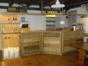 un bar con bancali in legno in una stanza con bottiglie di vino di Agriturismo Cornolade a Ponte nellʼAlpi Altre 26 foto