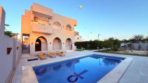 a house with a swimming pool next to a building at Magic Garden House in Luxor