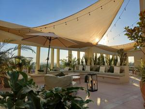 a patio with a large umbrella and couches at Loft Centro Zapopan in Guadalajara +5 photos