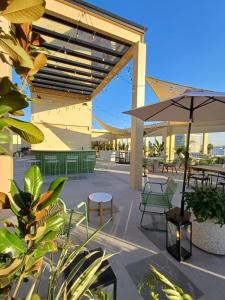a patio with tables and chairs and an umbrella at Loft Centro Zapopan in Guadalajara
